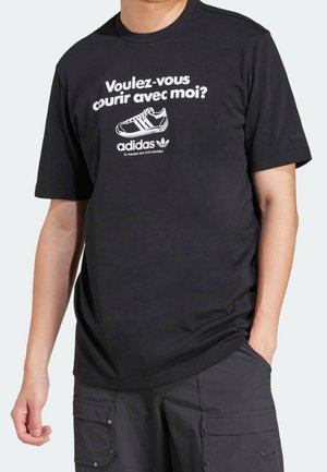 Černé tričko s bílým textem "Voulez-vous courir avec moi?" a grafikou boty Adidas; kulatý výstřih, krátké rukávy, měkká tkanina.