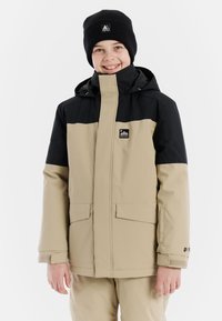 Beige und schwarze wasserdichte Jacke mit Kapuze, vorderen Taschen, verstellbaren Manschetten und einem Logo auf der linken Brust. Warmer schwarzer Strickbeanie.