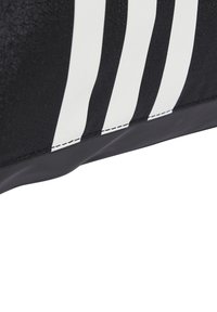 Bolsa deportiva de tela negra con tres franjas blancas. Presenta una textura suave y una forma redondeada, con costuras reforzadas en el borde.