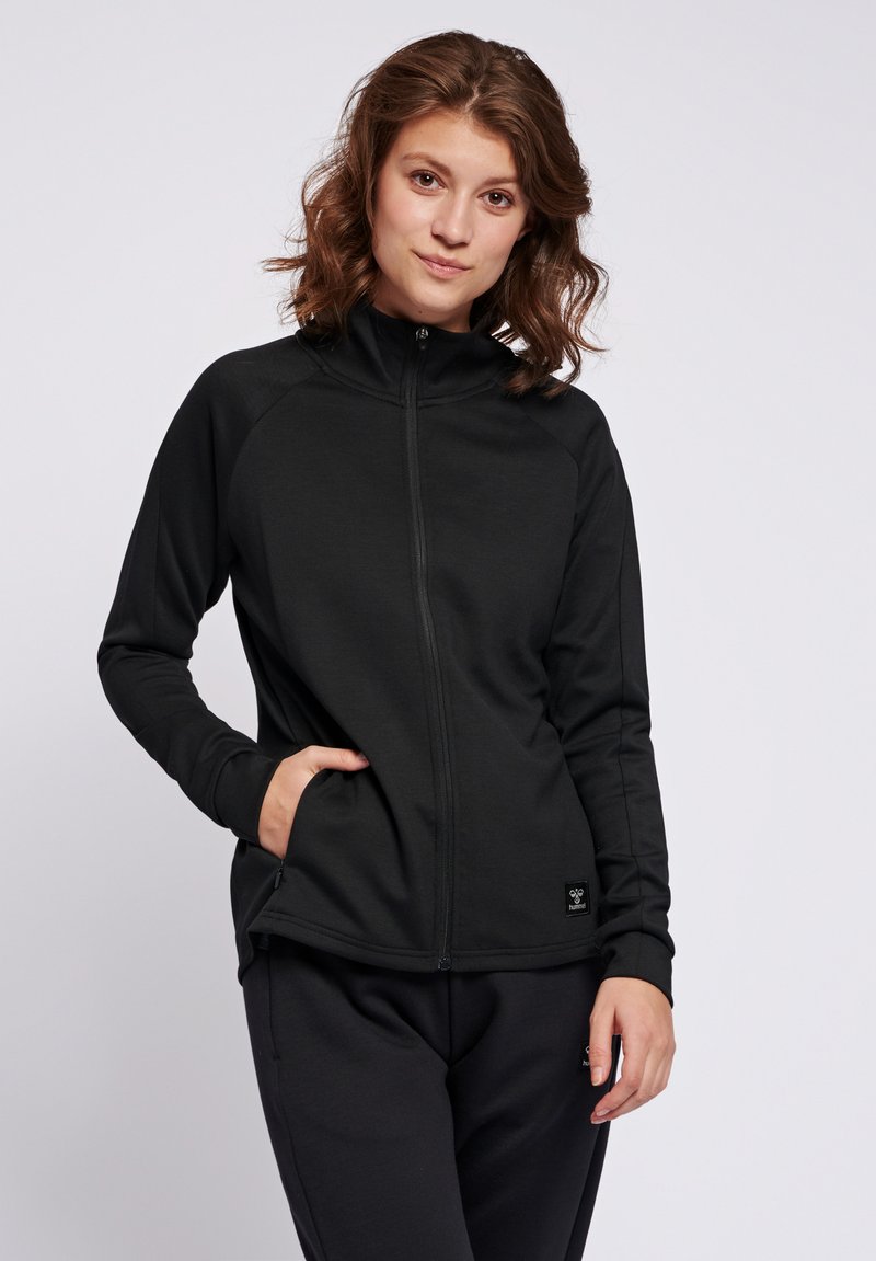 Giacca nera con zip realizzata in tessuto morbido, dotata di maniche lunghe, colletto alto e tasche laterali. Design semplice senza modelli prominenti.