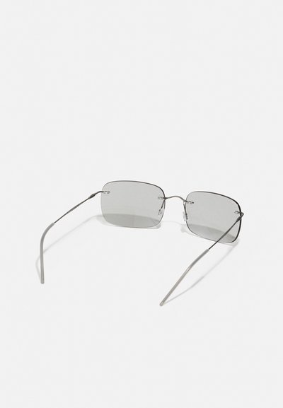 Lunettes de soleil rectangulaires avec des verres teintés gris, une fine monture en métal argenté, des branches droites et des repose-nez subtils pour le confort.