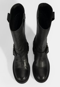 Zwarte leren laarzen tot de kuit met een textuurafwerking, voorzien van een zijgespdetail en trekriemen aan de bovenkant voor eenvoudig aan- en uittrekken.