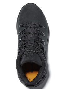 Baskets en suede noir avec finition texturée, six lacets noirs, col rembourré et semelle intérieure jaune. Présente une empreinte de logo sur la languette.