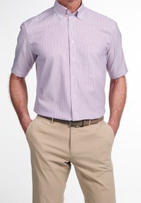 Short-sleeve button-up shirt in light purple and white stripes, with a collar and single chest pocket, paired with beige trousers and a brown belt.