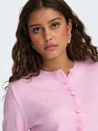 Pink knit cardigan with round neckline, button closure, and ribbed edges. Soft texture and lightweight fabric. Subtle tonal variations.