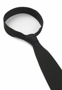 Cravatta nera realizzata in tessuto testurizzato, con un nodo liscio e un'estremità piatta e affusolata. Semplice e uniforme nel colore e nel design.