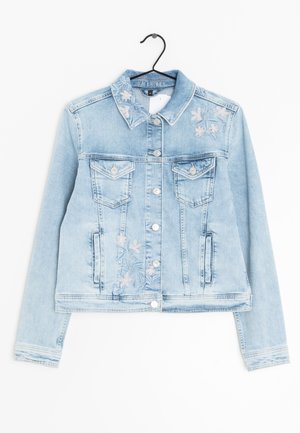 Veste en jean bleu clair avec des fleurs roses brodées sur le col, la poitrine et le devant, fermeture par boutons et poches à rabat poitrine sur un cintre noir.