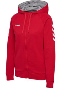 Sweat à zip rouge avec une doublure intérieure grise, orné d'un logo sur la poitrine et de motifs en chevron blancs sur les manches. Matériau en mélange de coton.