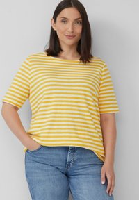 Gelb- und weiß gestreiftes Kurzarmhemd mit lässiger Passform. Der Stoff wirkt weich und wird mit blauen Jeans für lässige Outfits kombiniert.