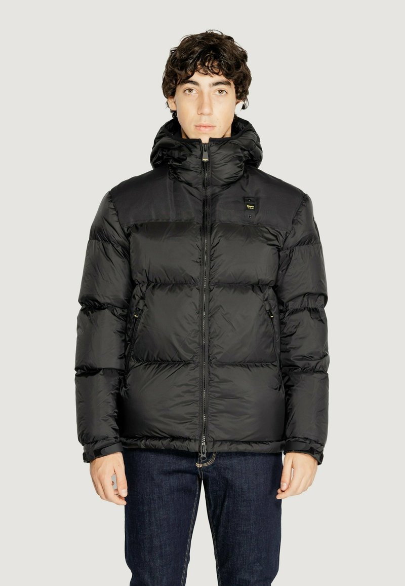 Giubbotto imbottito nero con colletto alto, zip frontale e tasche con zip. Realizzato in nylon lucido con un design trapuntato.