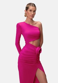 Fuchsiové jednoramenné šaty vyrobené z elastického materiálu, s prekrúteným dizajnom, zvrásnenou textúrou a kvetinovým akcentom v páse, s bočným rozparkom.