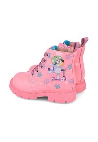 Botas de niña de color rosa brillante con suela de goma, que presentan un personaje de dibujos animados en un patinete y patrones de estrellas, diseño de cordones y tiradores en el talón.