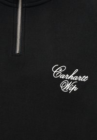 Μαύρο πλεκτό ύφασμα με ασημένιο φερμουάρ και λευκό κεντημένο λογότυπο «Carhartt Wip» σε καλλιγραφική γραφή στο μπροστινό μέρος.