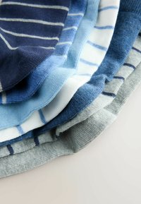 Stos skarpetek w różnych odcieniach niebieskiego i szarości, z poziomymi paskami o różnej szerokości, wykonanych z miękkiej dzianiny.