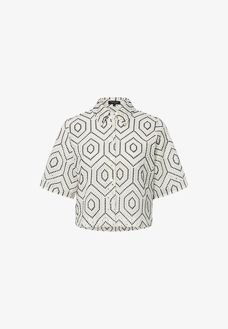 Korte mouwen blouse in crèmekleurige stof met een zwart hexagonaal patroon, voorzien van een kraag en knoopsluiting. De textuurontwerp voegt dimensie toe.
