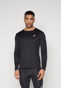 Sort langærmet sportsbluse lavet af letvægtsstof, med en rund halsudskæring og et lille hvidt logo på brystet.