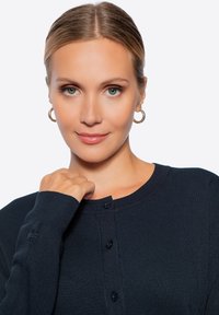 Námořnický modrý svetr s ribbovanou texturou, s kulatým výstřihem, knoflíkovým zapínáním a malým vyšitým logem na rukávu.