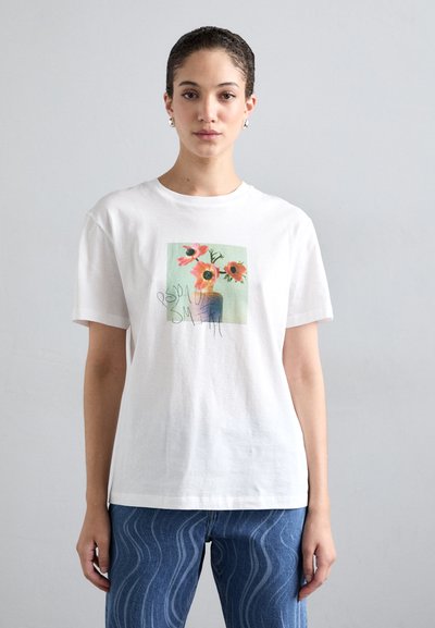 Tricou alb din bumbac cu imprimeu floral în nuanțe de roz și verde. Mâneci scurte și croială lejeră, cu un design minimalist și fără accente proeminente.