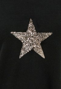 Vêtement noir avec un grand accent en sequins en forme d'étoile dans des tons de bronze métalliques, avec une texture lisse et une forme distincte en cinq points.