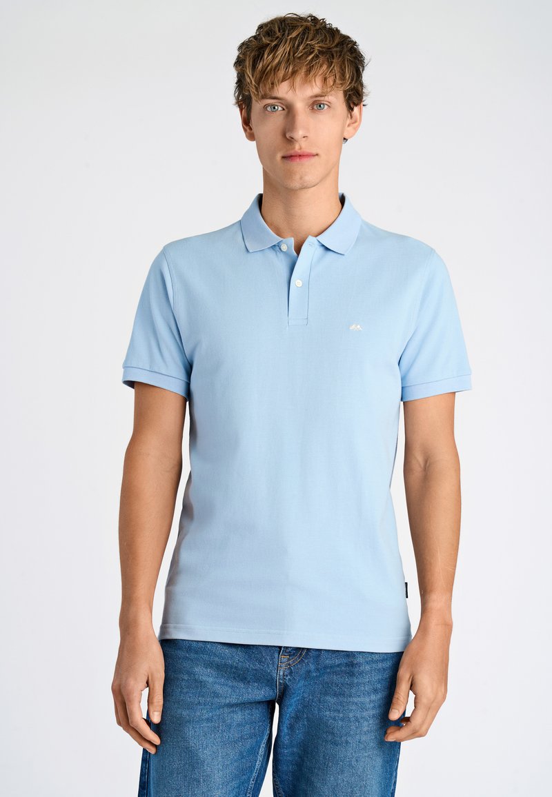 Polo shirt azzurro chiaro con collo a camicia, maniche corte e un piccolo logo bianco sul petto. Tessuto liscio e texture.}}