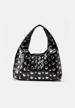 Sac bandoulière en cuir noir avec des clous circulaires argentés de différentes tailles couvrant la surface et une large anse pour le porter.