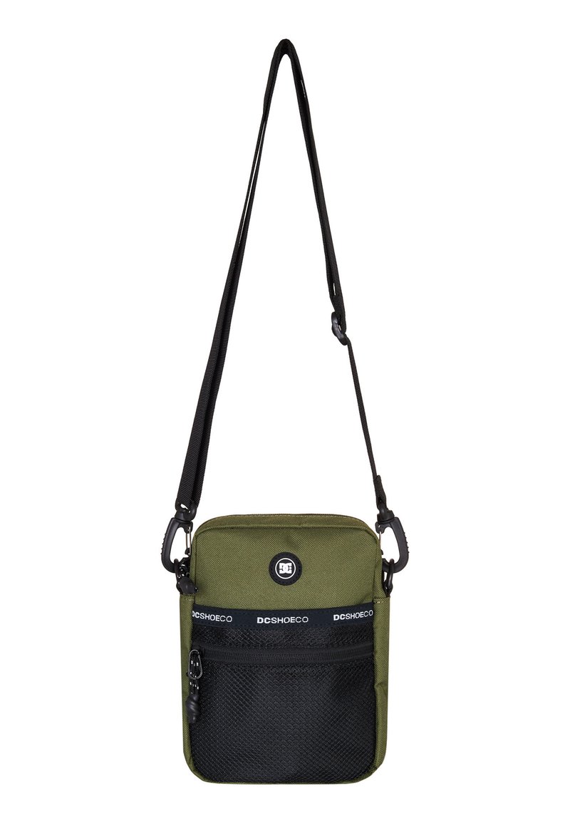 Zelená crossbody taška vyrobená z odolného materiálu, so sieťovanou prednou kapsou v čiernej farbe, nastaviteľným popruhom a logom na prednej strane.