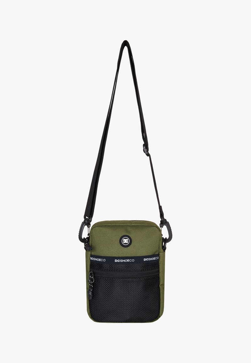 Zelená crossbody taška vyrobená z odolného materiálu, so sieťovanou prednou kapsou v čiernej farbe, nastaviteľným popruhom a logom na prednej strane.