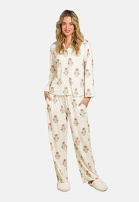 Floraal-patroon pyjama set in crème, met lange mouwen, een knoopsluiting bovenstuk en losse broek met zijzakken. Zachte, lichte stof.