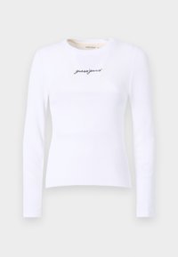 Biele dlhé tričko s ryhou, na hrudi s výšivkou názvu značky "guessjeans" v čiernej farbe. Hladká textúra, priliehavý strih.