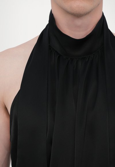 Mustmust paelteksaga top, mis on valmistatud siledast kangast ja millel on volditud detailid kaeluse ja avatud õlgadel, luues stiilse siluetti.