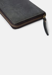 Black leather wallet with a smooth texture, gold zipper, and a tan accent on the zipper pull. Dark, minimalist design without visible logos.