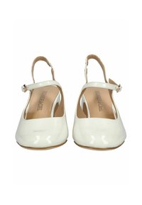 Zapatos slingback de charol blanco con punta redondeada, correa en el tobillo y interior beige. Textura suave con un acabado brillante.