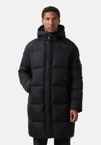 Sort polstret lang frakke med hætte, der har en frontlynlås, trykknapper og sidelommer. Materialet har en glat, glinsende tekstur.