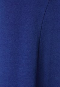 Kungsblått tyg med en mjuk textur, som har en enfärgad yta med en lätt glans, och uppvisar en ren, enkel design utan mönster.