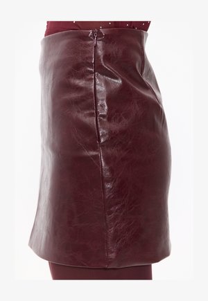 Mini-jupe en cuir bordeaux avec une finition brillante, dotée d'une fermeture éclair sur le côté et d'une texture lisse, conçue pour une silhouette ajustée.