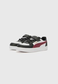 Baskets noir et blanc avec une touche de marron, présentant une tige en synthétique texturé, des lacets plats et un col rembourré pour le soutien.