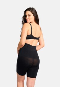 Zwarte shapewear shorts met een hoge tailleband, gemaakt van een gladde, rekbare stof en van gemiddelde dijlengte. Verstelbare bandjes op de bh.