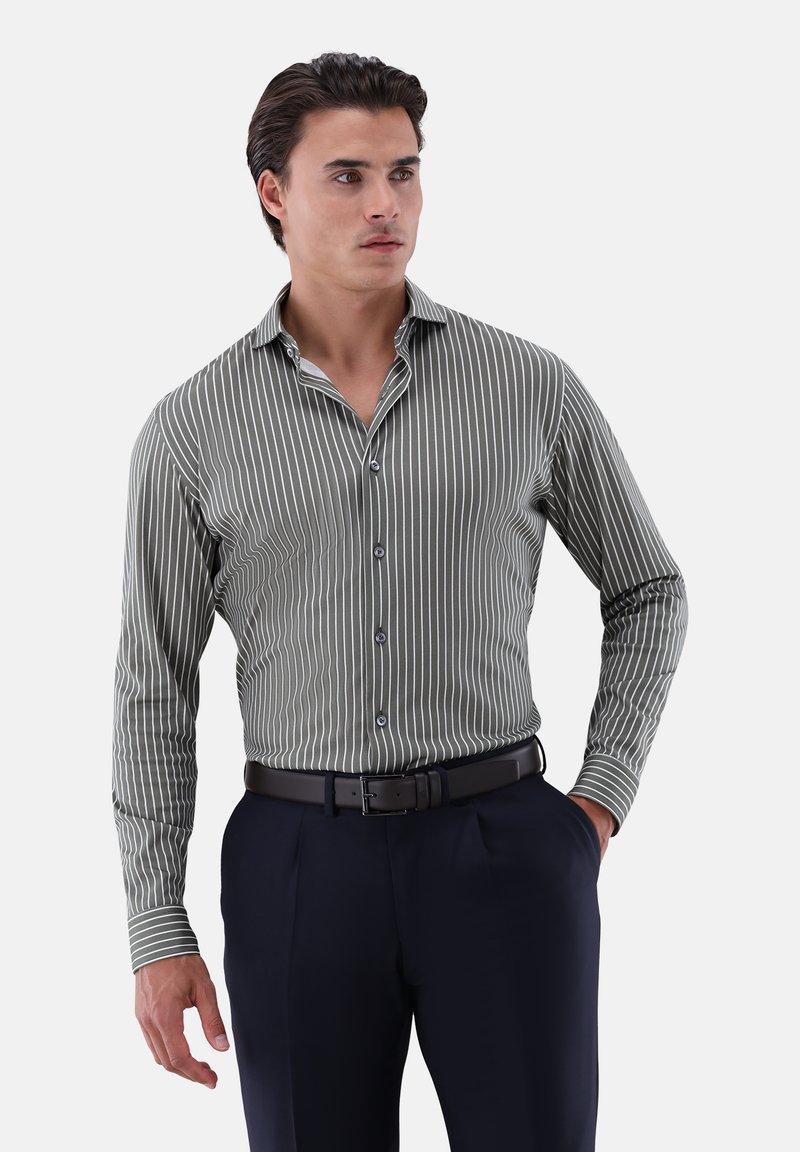 Camicia a maniche lunghe a righe verdi con colletto abbottonato, caratterizzata da sottili righe verticali bianche, abbinata a pantaloni scuri e una cintura nera.