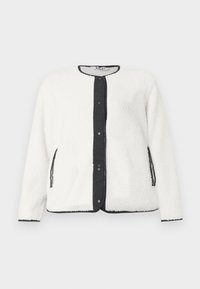 Veste en polaire blanche avec patte de boutonnage et finitions en rib noir. Elle comporte deux poches latérales et un tissu texturé pour plus de chaleur.