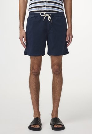 Navy swim shorts made of lightweight fabric, featuring an elastic waistband with a drawstring and side pockets, above the knee length.