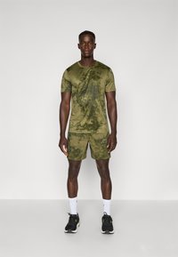 Olijfgroen sportshirt en shorts set met een camouflagepatroon, lichtgewicht stof, korte mouwen en een logo op de borst.