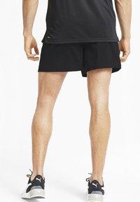 Svarta sportshorts i lätt material, med lös passform och rak fåll. Matcher med svarta och vita sneakers.