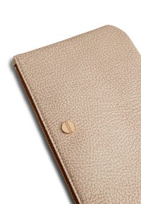 Clutch in pelle di un rosa chiaro con texture, caratterizzato da una zip circolare in oro e un design pulito e minimalista.