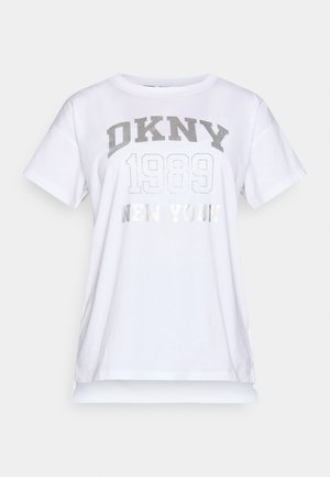 Fehér pamut póló, lekerekített nyakkivágással, rövid ujjakkal, elöl ezüst színű grafikus szöveggel, amelyen a "DKNY 1989 NEW YORK" szerepel.