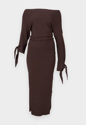 Brun ribbestrikket kjole med bare skuldre, lange ermer bundet ved håndleddene og en tettsittende midilang skjørt med sidespalte.