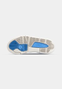 Semelle de sneaker en caoutchouc blanc avec un accent bleu. Motif de traction pour l'adhérence, section lisse près du talon, et détail de logo en relief.