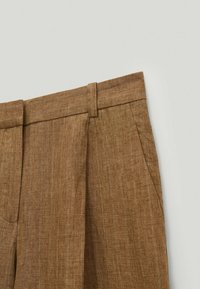 Pantalon sur mesure en tissu marron à fines rayures, doté de passants pour ceinture, de poches latérales et d'un pli frontal.