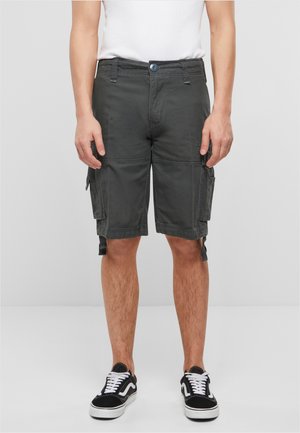 Shorts cargo en tissu gris foncé, avec des poches latérales, des ourlets ajustables et une fermeture à bouton. Portés avec des baskets noires et blanches.