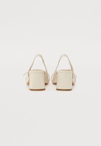 Beige blokkhelte sandaler med ankelreimer, glatt kunstlærtekstur, åpen tå-design og en lysebrun såle.