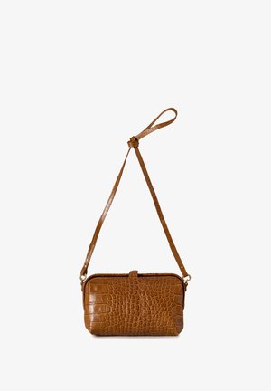 Bolso cruzado de cuero marrón con textura de cocodrilo, con correa ajustable y cierre superior de broche sobre un fondo blanco.